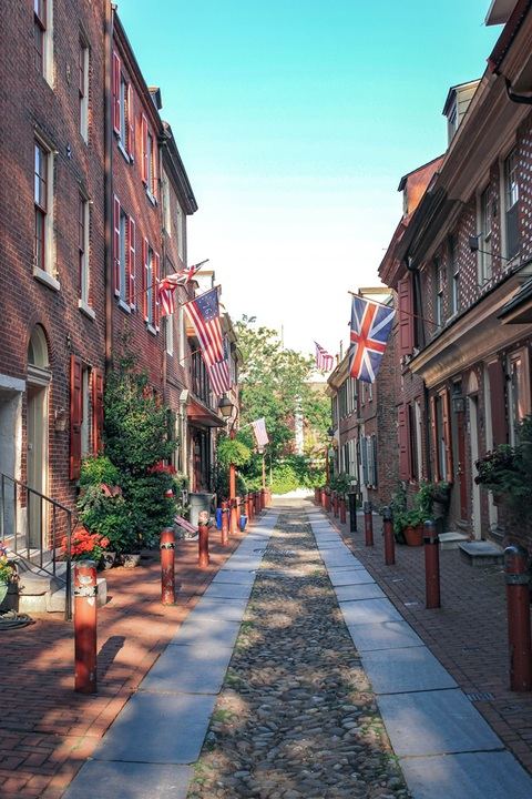 Colonial brick rowhouses and flags along Elfreth's Alley, the oldest residential street in America